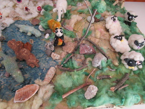 阿部製粉の紙袋の上に展開されている羊毛のジオラマ。羊、パンダ、ワニ、象などの動物たちが飾られている