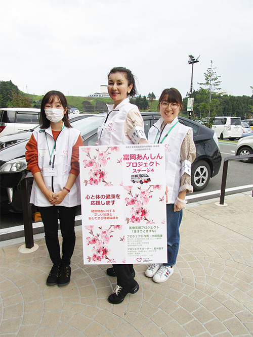 同じく東北大学学生ボランティアの二人と、１０月１０日に開催の福島県庁事業“富岡あんしんプロジェクト”のポスターを広げる石井