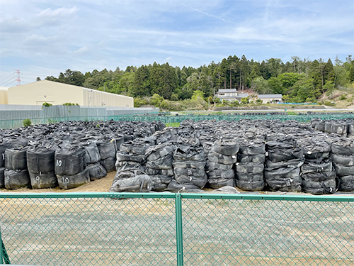 放射性物質に汚染された廃棄物の黒い袋の山が積まれている